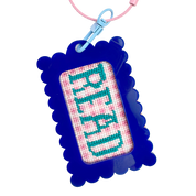 Cross-stitched keychain with 'Read' text in a blue bag tag frame against a white background
