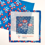 Needlepoint canvas kit with floral design  by and blue fabric with red and white pattern. Pattern is Juliet from Handker