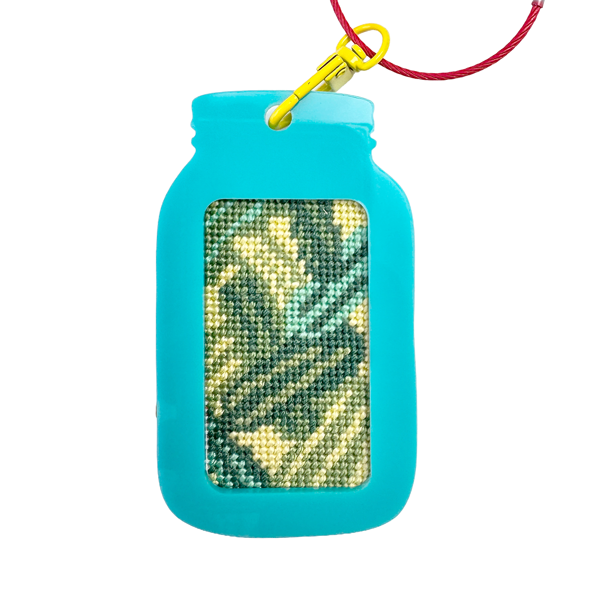 Turquoise mason jar-shaped keychain fram with a red wire and yellow clip on a white background. needlepoint design with green and yellow pickles