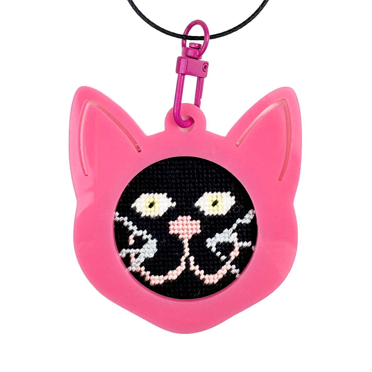 Pink cat-shaped needlepoint keychain with a black background