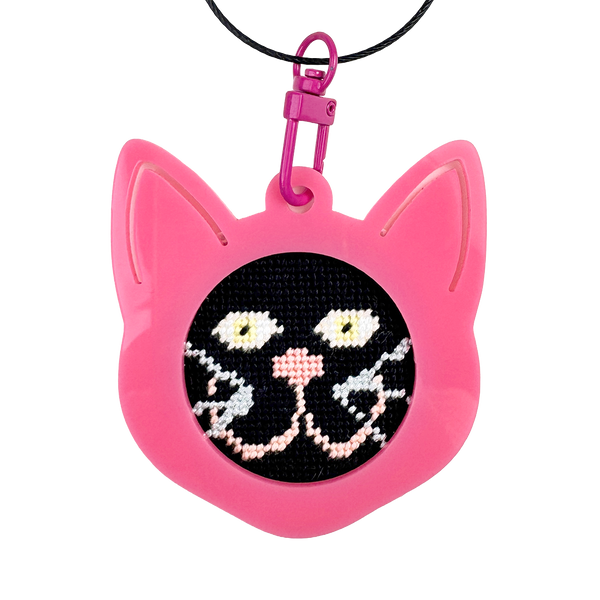 Pink cat-shaped needlepoint keychain with a black background
